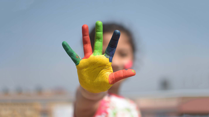 Kind mit bunten Händen